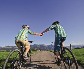 couple holding hands while cycling