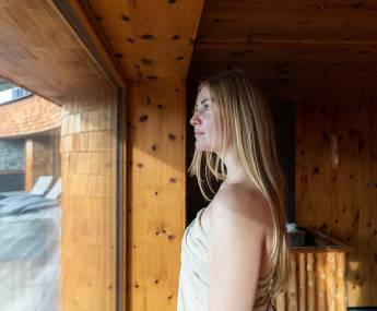 Dame die die Aussicht aus der Zirben-Salz-Sauna genießt