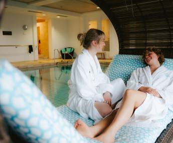Women on the lounge chairs at the indoor pool