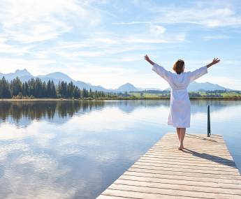 woman with bathrobe on a jetty 