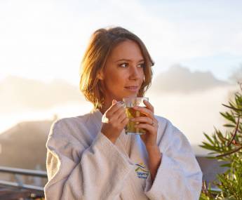 Frau mit Tee auf Terrasse