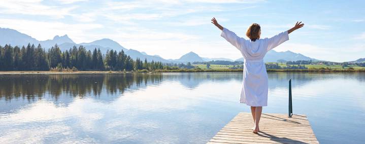 Frau im Bademantel am See