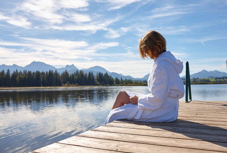 woman sitting on a jetty hotel hopfen am see