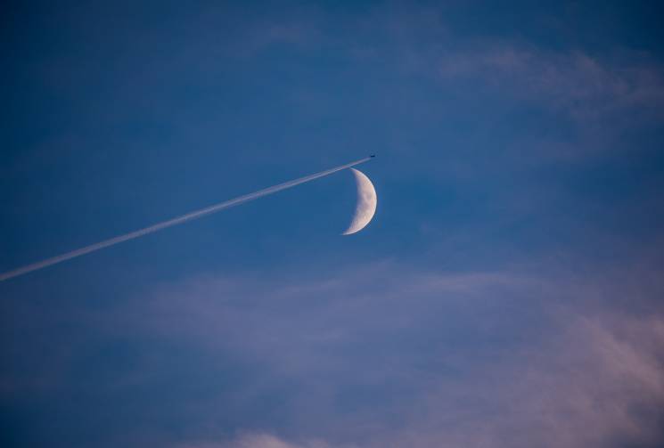 Flugzeug fliegt am Mond vorbei