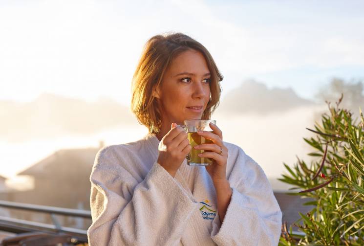 Frau mit Tee auf der Terrasse